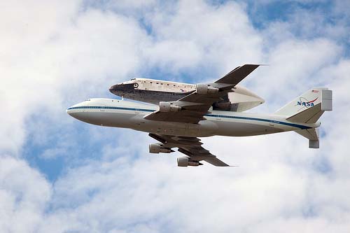The Space Shuttle Discovery, piggybacking on the Shuttle Carrier Aircraft, in flight.