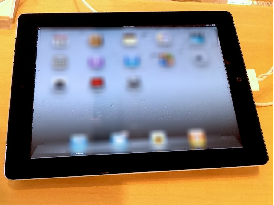A black iPad showing blurred icons on its screen.